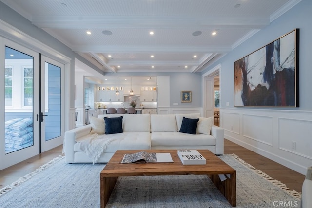 living area featuring recessed lighting, a wainscoted wall, beam ceiling, light wood finished floors, and a decorative wall