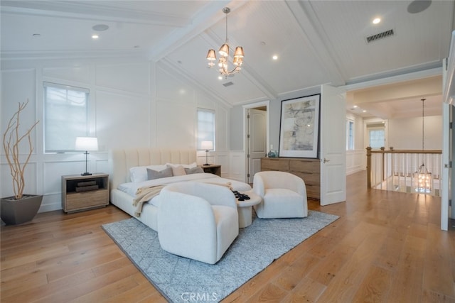 bedroom with visible vents, light wood finished floors, lofted ceiling with beams, a decorative wall, and a notable chandelier