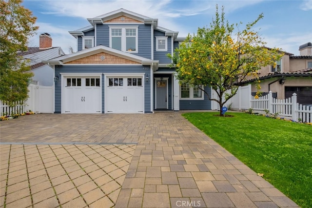 view of front of house featuring decorative driveway, a front yard, and fence