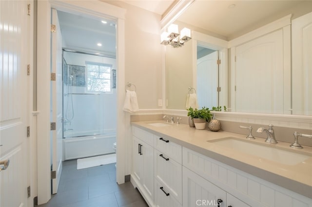 bathroom with double vanity, tile patterned flooring, toilet, and a sink