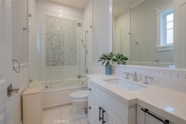 full bathroom featuring tile patterned floors, shower / bath combination with glass door, toilet, and vanity