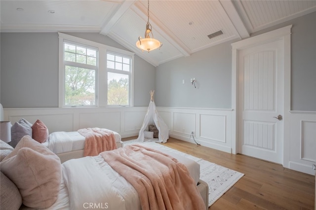 bedroom featuring visible vents, a wainscoted wall, light wood-style floors, wooden ceiling, and vaulted ceiling with beams