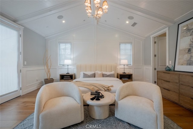 bedroom with vaulted ceiling with beams, wood finished floors, a decorative wall, and an inviting chandelier