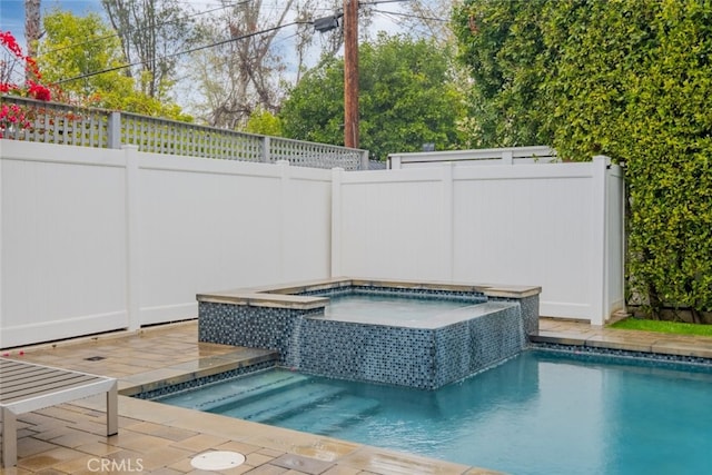 view of swimming pool with an in ground hot tub and fence