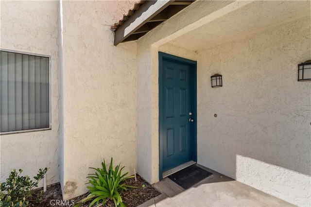 property entrance with stucco siding