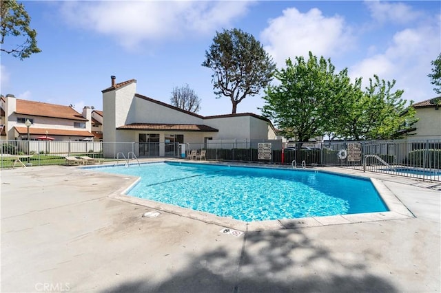 community pool featuring a patio area and fence