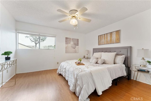 bedroom featuring a textured ceiling, ceiling fan, and wood finished floors