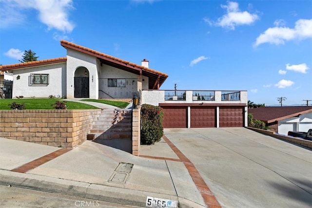 view of front of property featuring a tiled roof, stairway, a chimney, and stucco siding