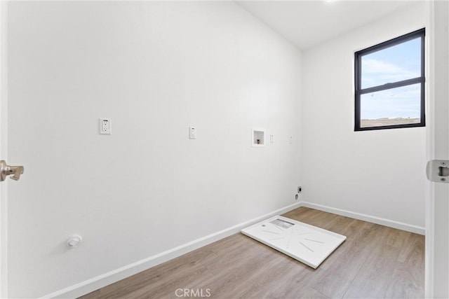 clothes washing area featuring baseboards, washer hookup, wood finished floors, and laundry area