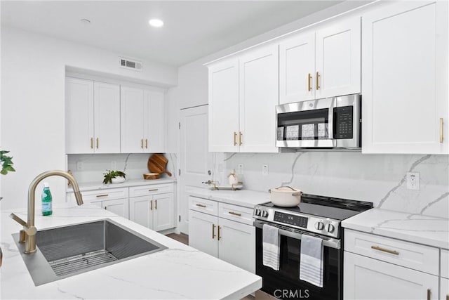 kitchen with white cabinets, appliances with stainless steel finishes, and a sink