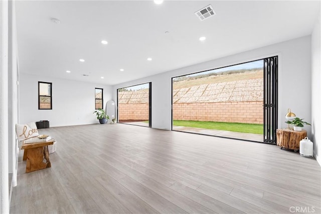 unfurnished living room featuring recessed lighting, visible vents, and wood finished floors