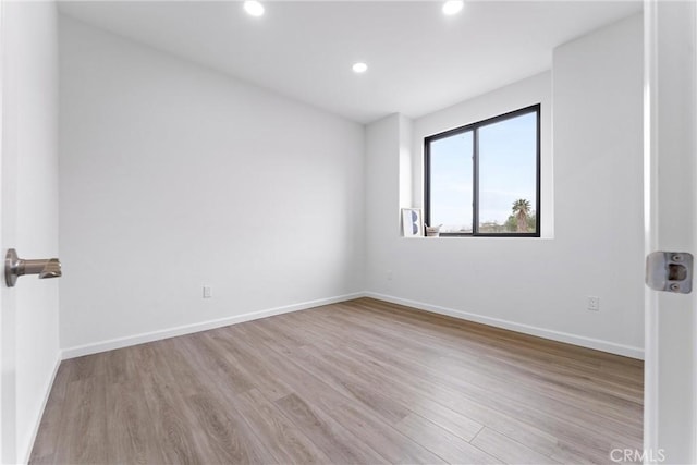 empty room featuring recessed lighting, baseboards, and wood finished floors