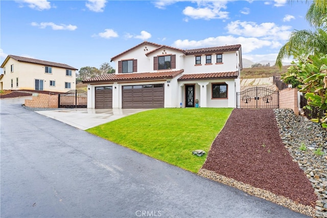 mediterranean / spanish house with fence, a tiled roof, a front yard, driveway, and a gate