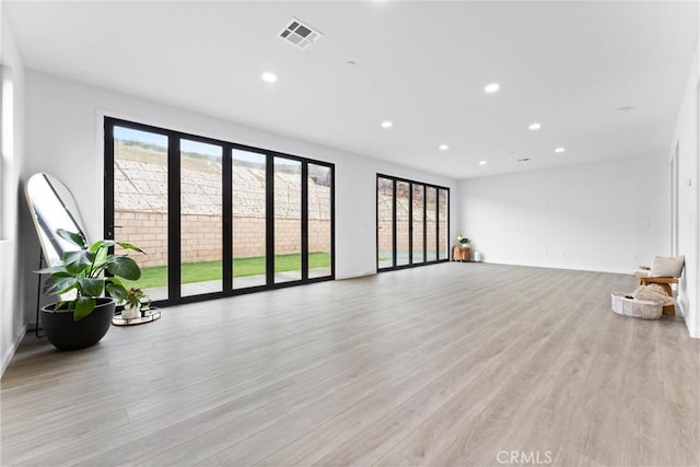 unfurnished living room featuring visible vents, recessed lighting, and light wood-style floors