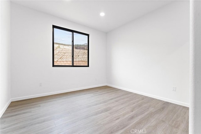 empty room with recessed lighting, baseboards, and light wood-type flooring