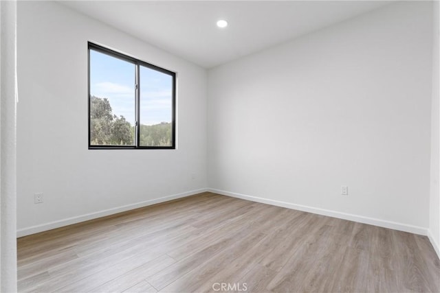 empty room with recessed lighting, baseboards, and light wood finished floors