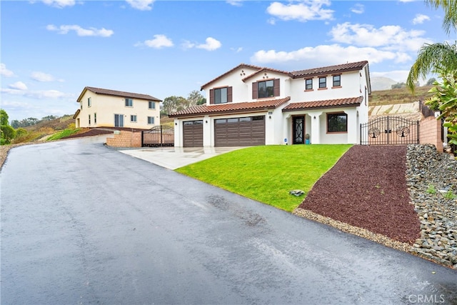 mediterranean / spanish home featuring fence, aphalt driveway, a front yard, stucco siding, and a gate