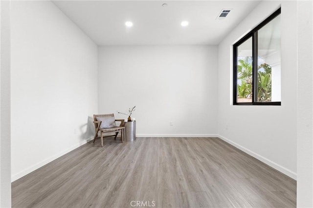 spare room with visible vents, recessed lighting, baseboards, and wood finished floors