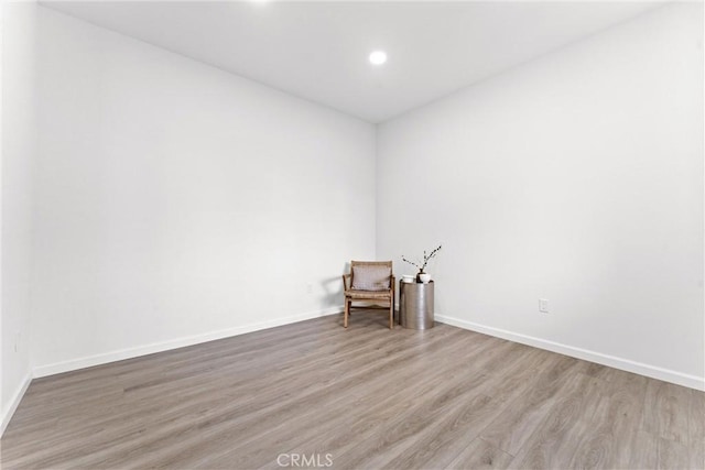 empty room with recessed lighting, wood finished floors, and baseboards