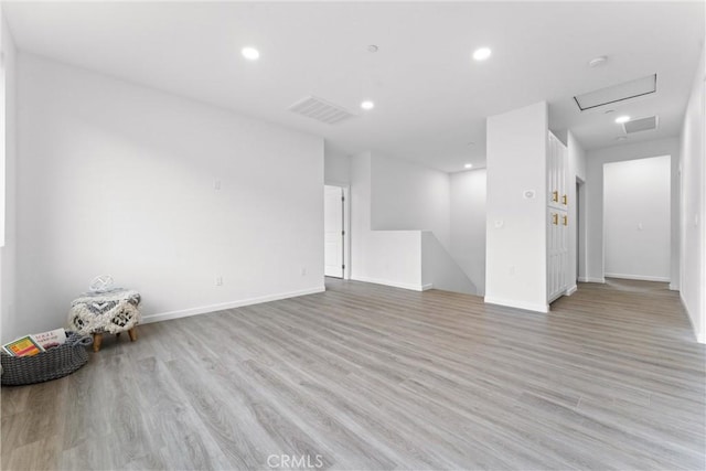 interior space with visible vents, baseboards, attic access, recessed lighting, and light wood-style floors