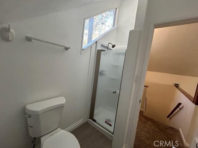 full bathroom featuring a stall shower, toilet, and baseboards