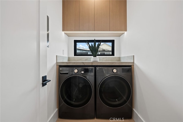 washroom with cabinet space and washing machine and dryer