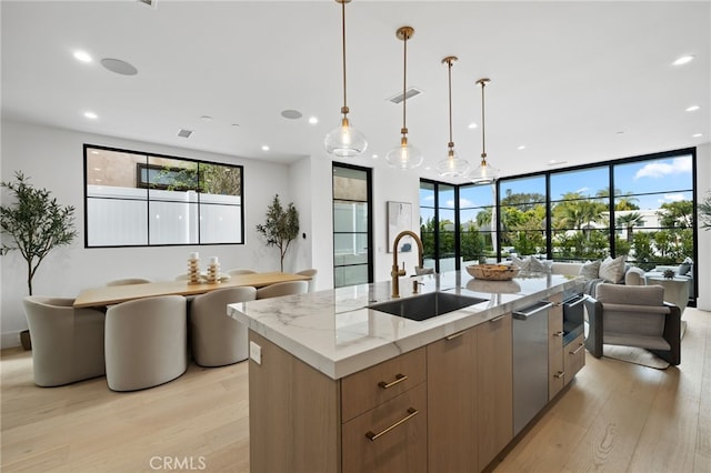 kitchen featuring a sink, light wood-type flooring, modern cabinets, and open floor plan