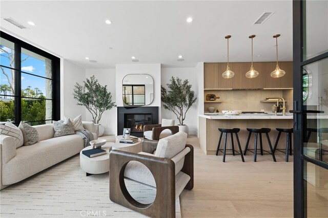 506 Avocado Ave, Corona Del Mar, CA 92625 - living area with visible vents, recessed lighting, light wood-style floors, and a glass covered fireplace