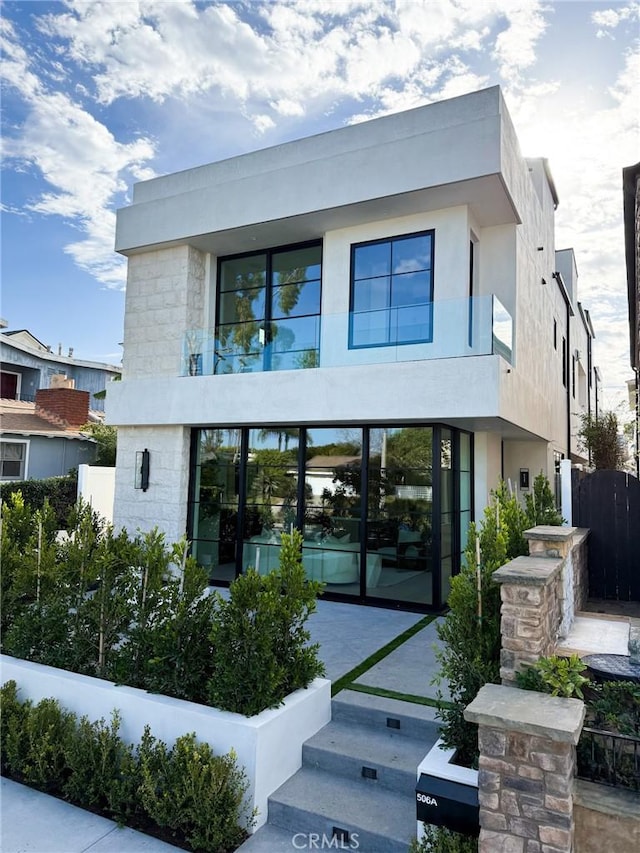 view of front of home featuring a balcony and stucco siding