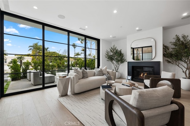 506 Avocado Ave, Corona Del Mar, CA 92625 - living room featuring visible vents, expansive windows, a glass covered fireplace, recessed lighting, and light wood finished floors