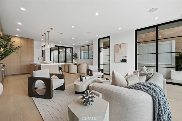 living area with light wood-style flooring, recessed lighting, and visible vents