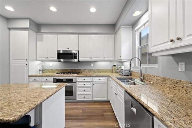 kitchen with a sink, dark wood-style floors, recessed lighting, stainless steel appliances, and white cabinets