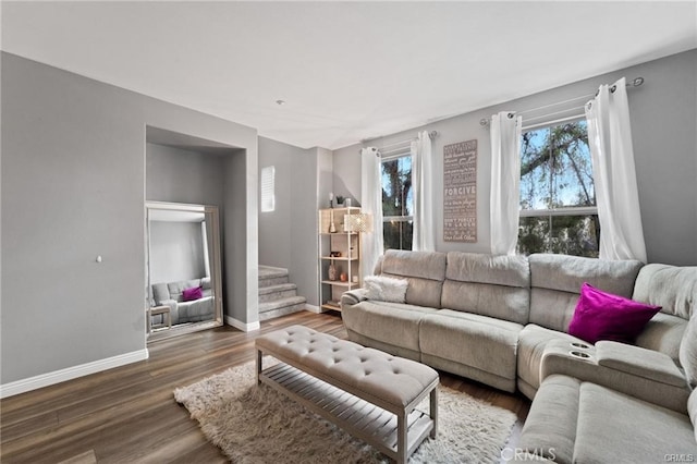 living area with stairway, wood finished floors, and baseboards