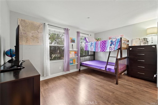 bedroom featuring baseboards and wood finished floors