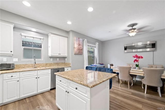 kitchen with a kitchen island, recessed lighting, stainless steel dishwasher, light wood-style floors, and a sink