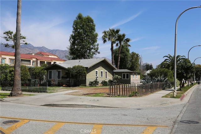 view of front facade with a fenced front yard and a mountain view