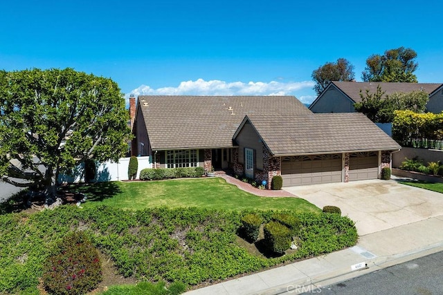 view of front facade featuring fence, an attached garage, a chimney, a front lawn, and concrete driveway