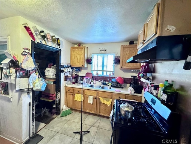 kitchen with under cabinet range hood, brown cabinets, stainless steel range with gas stovetop, and light countertops