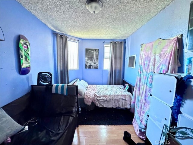 bedroom with a textured ceiling and wood finished floors