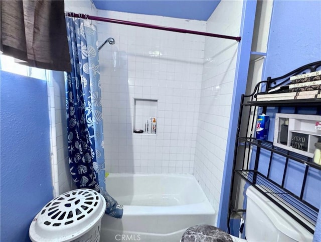 bathroom featuring shower / bath combo with shower curtain and a textured wall