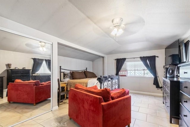 bedroom featuring light tile patterned floors, baseboards, ceiling fan, and vaulted ceiling