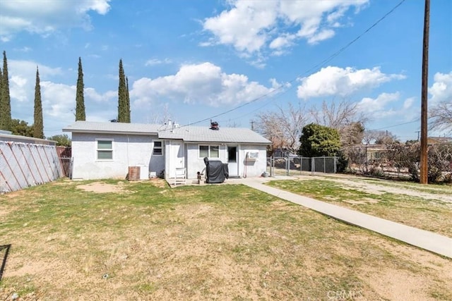 rear view of property featuring a yard and fence