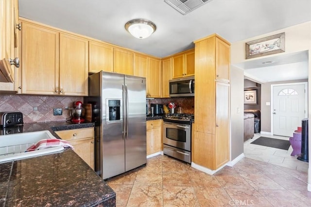 kitchen with light brown cabinets, visible vents, a sink, appliances with stainless steel finishes, and tasteful backsplash