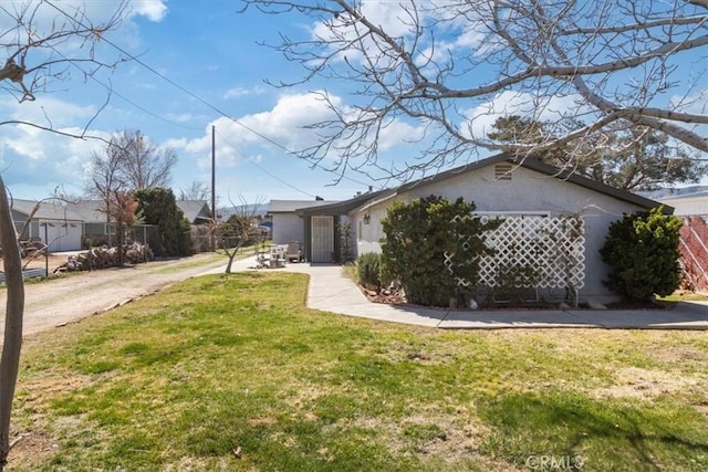 view of front of property featuring stucco siding and a front lawn