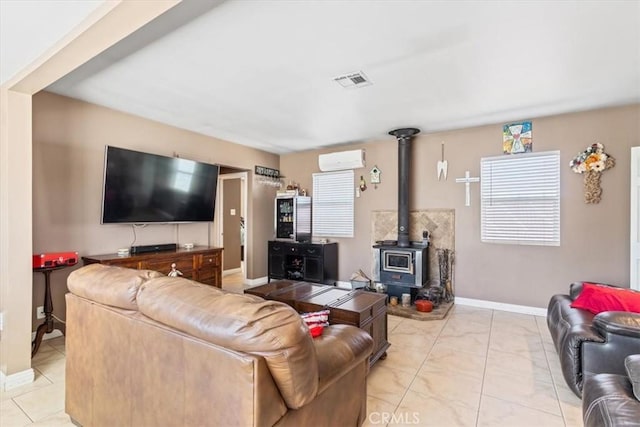 living area featuring visible vents, a wall mounted AC, light tile patterned floors, baseboards, and a wood stove