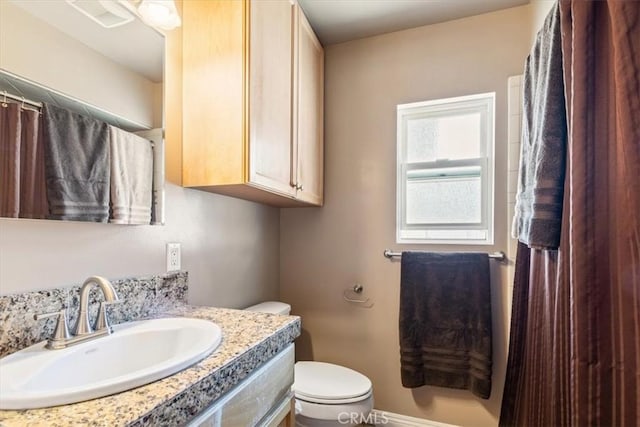 bathroom with visible vents, toilet, vanity, and baseboards