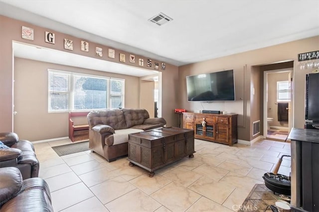 living room featuring plenty of natural light, visible vents, and light tile patterned floors