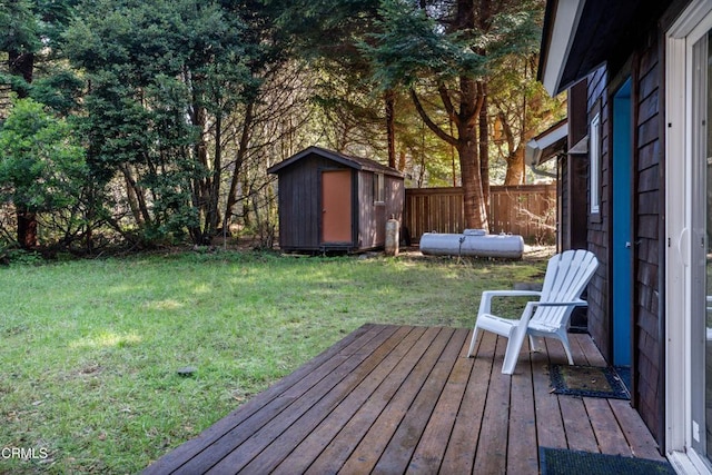 view of yard with a storage unit, a wooden deck, an outdoor structure, and fence