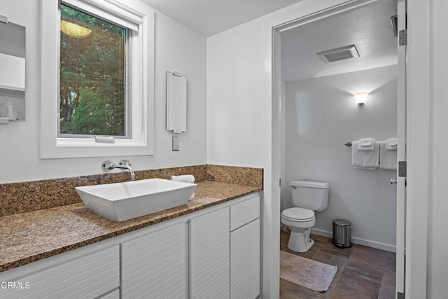 bathroom with visible vents, baseboards, toilet, and vanity