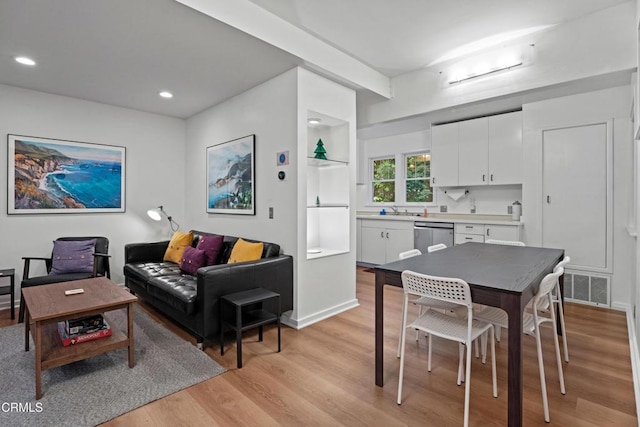 living room with recessed lighting, visible vents, and light wood finished floors